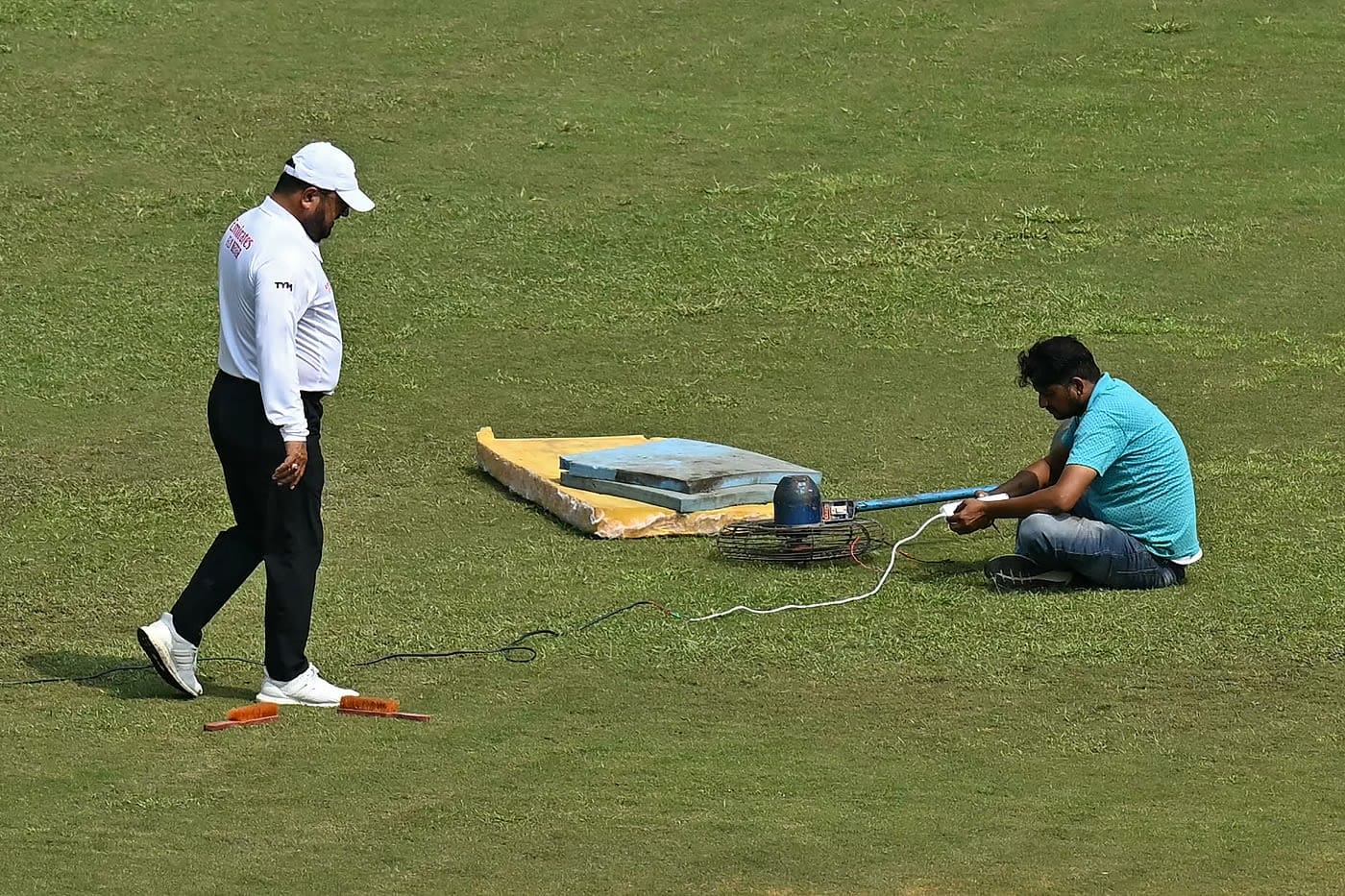 A groundsman uses a fan to dry a patch of wet outfield, Afghanistan vs New Zealand, Only Test, 2nd day, Greater Noida, September 10, 2024