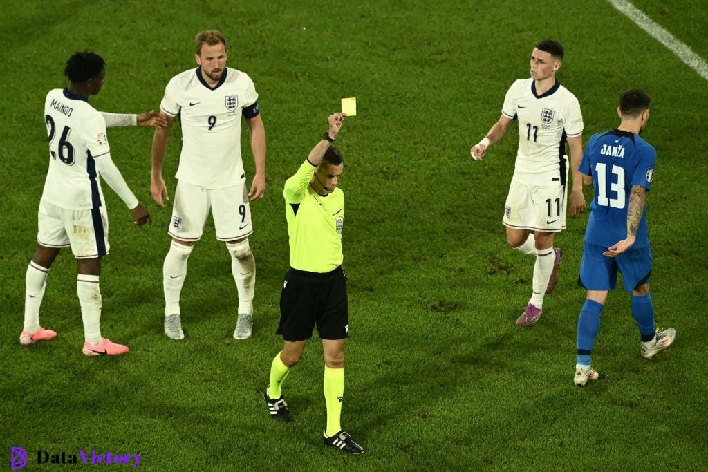 Clement Turpin brandishes a yellow card during England vs Slovenia