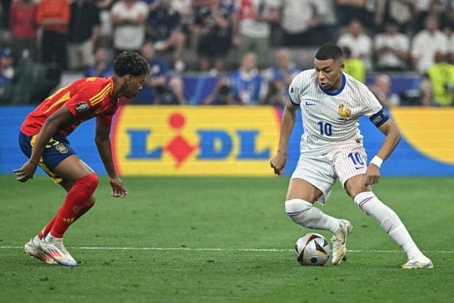 Kylian Mbappe of France takes on Lamine Yamal of Spain