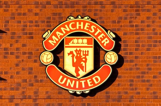 The Manchester United club crest on a brick wall outside Old Trafford