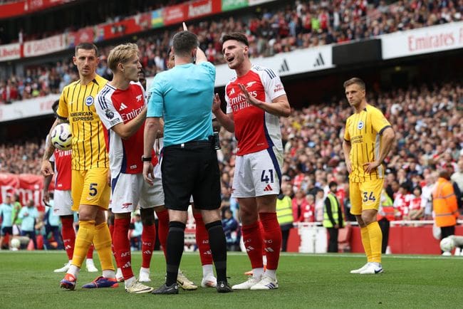 LONDON, ENGLAND - AUGUST 31: Declan Rice of Arsenal interacts with match referee Chris Kavanagh after being shown a second yellow card during the Premier League match between Arsenal FC and Brighton & Hove Albion FC at Emirates Stadium on August 31, 2024 in London, England. (Photo by Ryan Pierse/Getty Images)